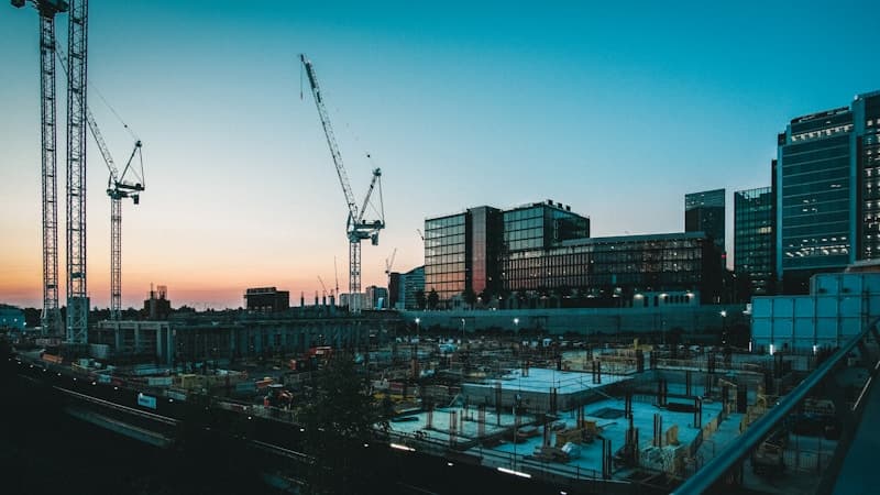 Construction site with tower cranes at sunset